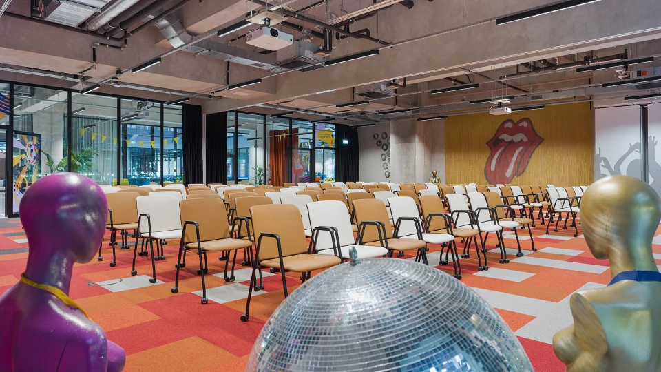 Crossover Stage im Smartvillage B-NK, Blick über die Stuhlreihen auf das Disco-Design und Mannequins.