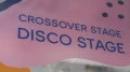 Nahaufnahme des pinken Türschildes mit der Aufschrift „Crossover Stage Disco Stage“.