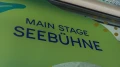 „Main Stage Seebühne“ auf einer organisch gestalteten, grünen Wandfläche mit Punkten und Formen im Hintergrund.