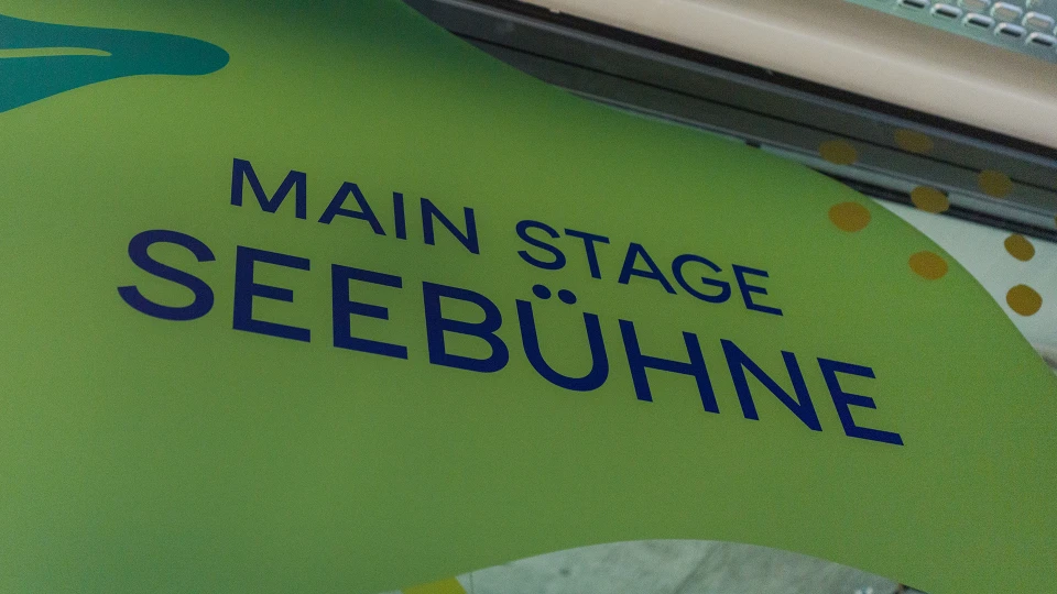 „Main Stage Seebühne“ auf einer organisch gestalteten, grünen Wandfläche mit Punkten und Formen im Hintergrund.