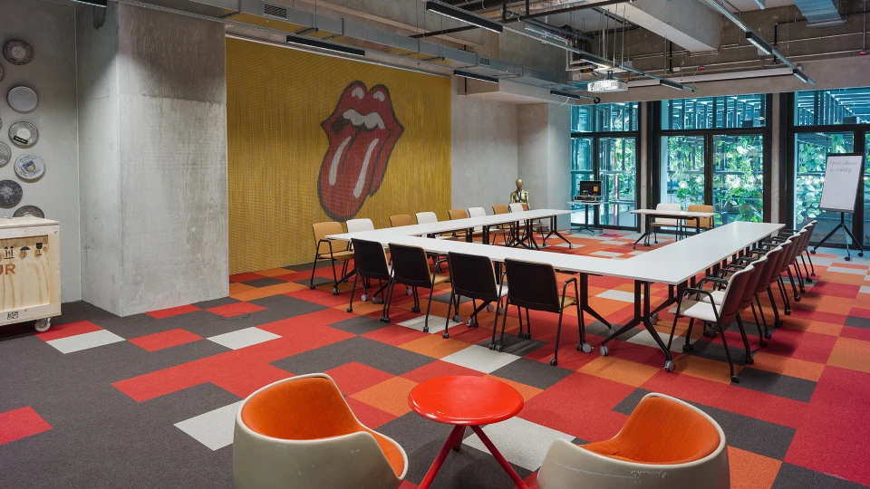 Rock Stage Konferenzraum mit Blick auf die Zungen-Grafik und U-förmig angeordnete Stühle und Tische, Dekor mit Schallplatten an der Wand.