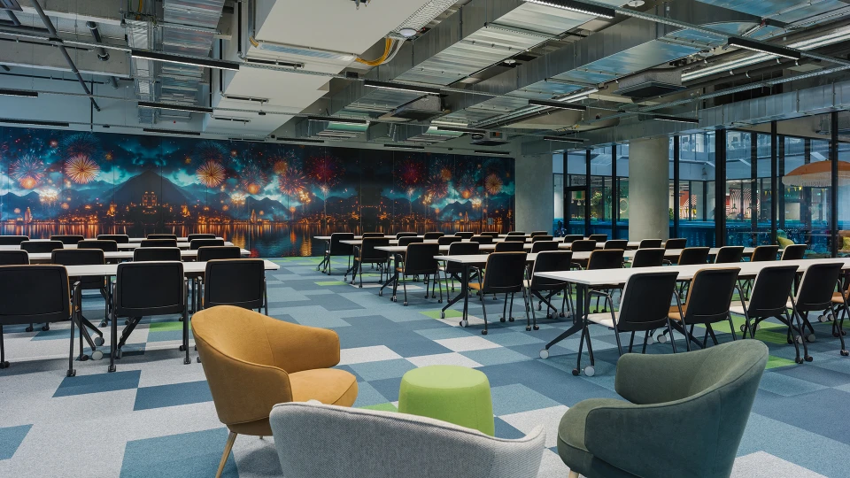 Konferenzraum mit Feuerwerkswand und gemütlicher Lounge-Ecke im Vordergrund.