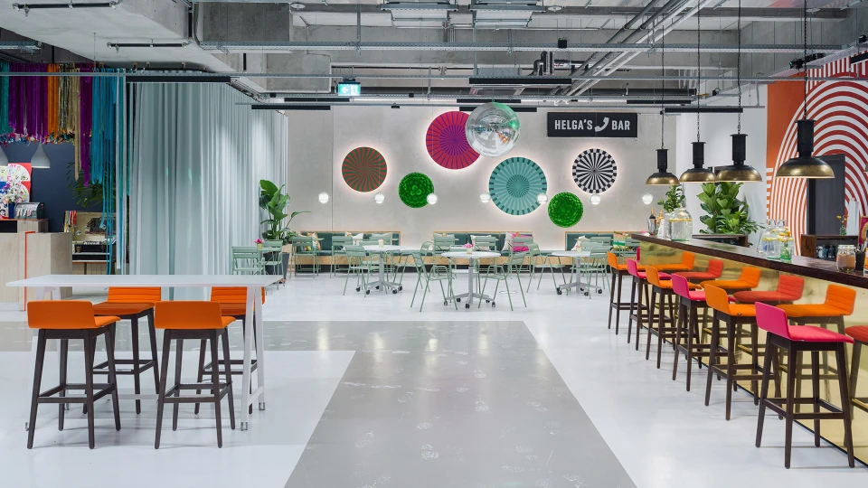 Symmetrical view of Helga's Bar featuring wall graphics and seating areas on both sides.