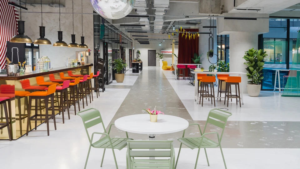 Wide-angle view of Helga's Bar featuring a decorative wall and light green seating in the foreground.