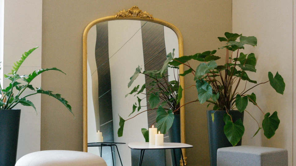 Gemütliche Lounge-Ecke mit Spiegel, Zimmerpflanzen und Sitzhockern im Tagungsraum Versailles, Smartvillage Bogenhausen.