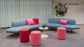 Gemütliche Sitzgruppe im Smartvillage Köln-Mülheim mit blauen Sofas und pinken Hockern