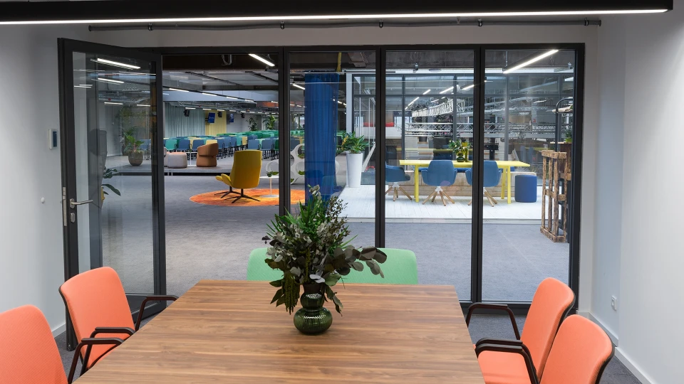 Meetingraum im Smartvillage Köln-Mülheim mit Glasfront und modernen Konferenzstühlen