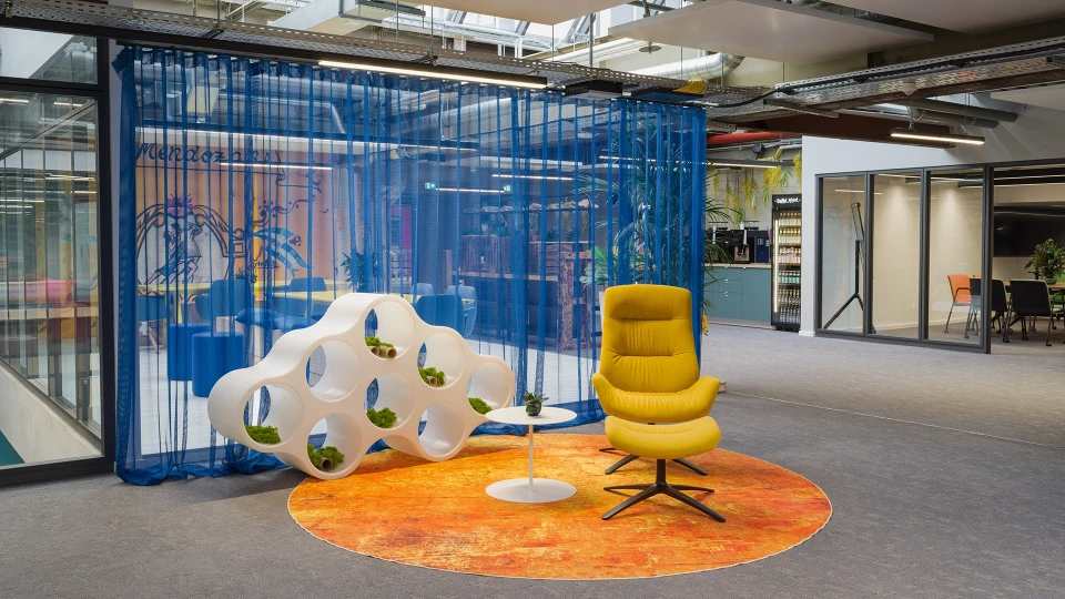 Design-Lounge im Smartvillage Köln-Mülheim mit gelbem Sessel und moderner Deko