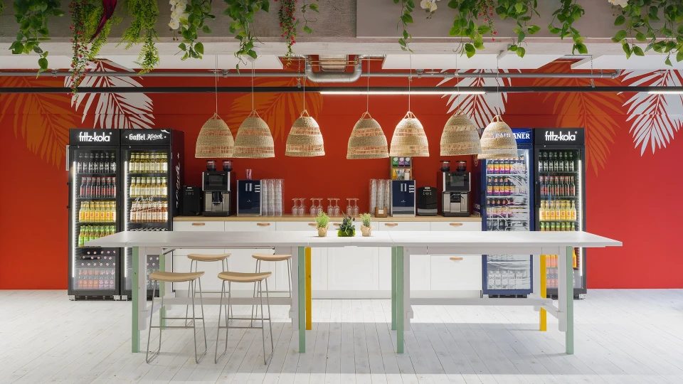 Übersicht über die Beachbar im Smartvillage Köln-Mülheim mit Hängelampen, Pflanzen und buntem Interieur.