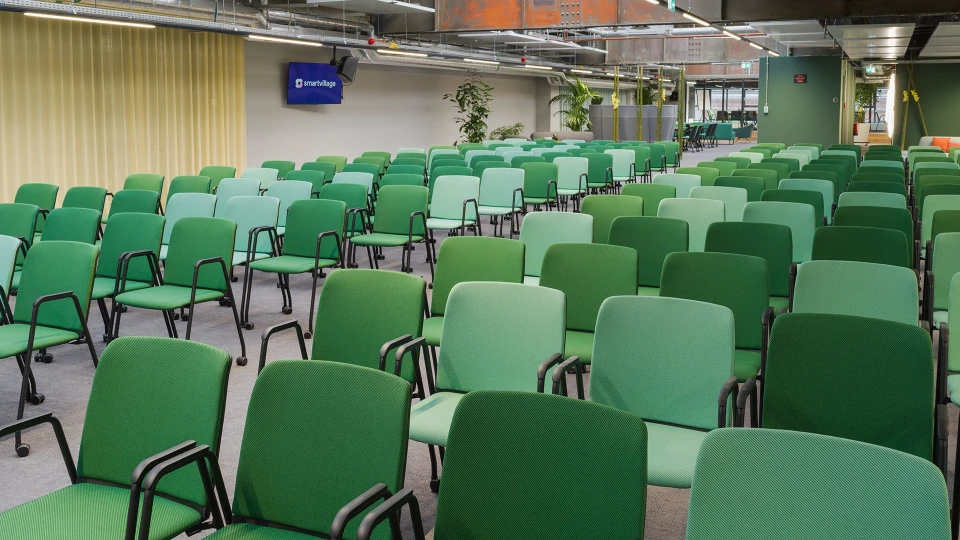 Raum Brasilien im Smartvillage Köln-Mülheim mit hellgrünen Stühlen, Holztischen und luftiger Architektur im Industrie-Look