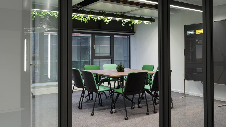 Grüne Sofas vor Wandgrafik der Selarón-Treppe im Smartvillage Köln-Mülheim, ideal für kreative Pausen und Networking