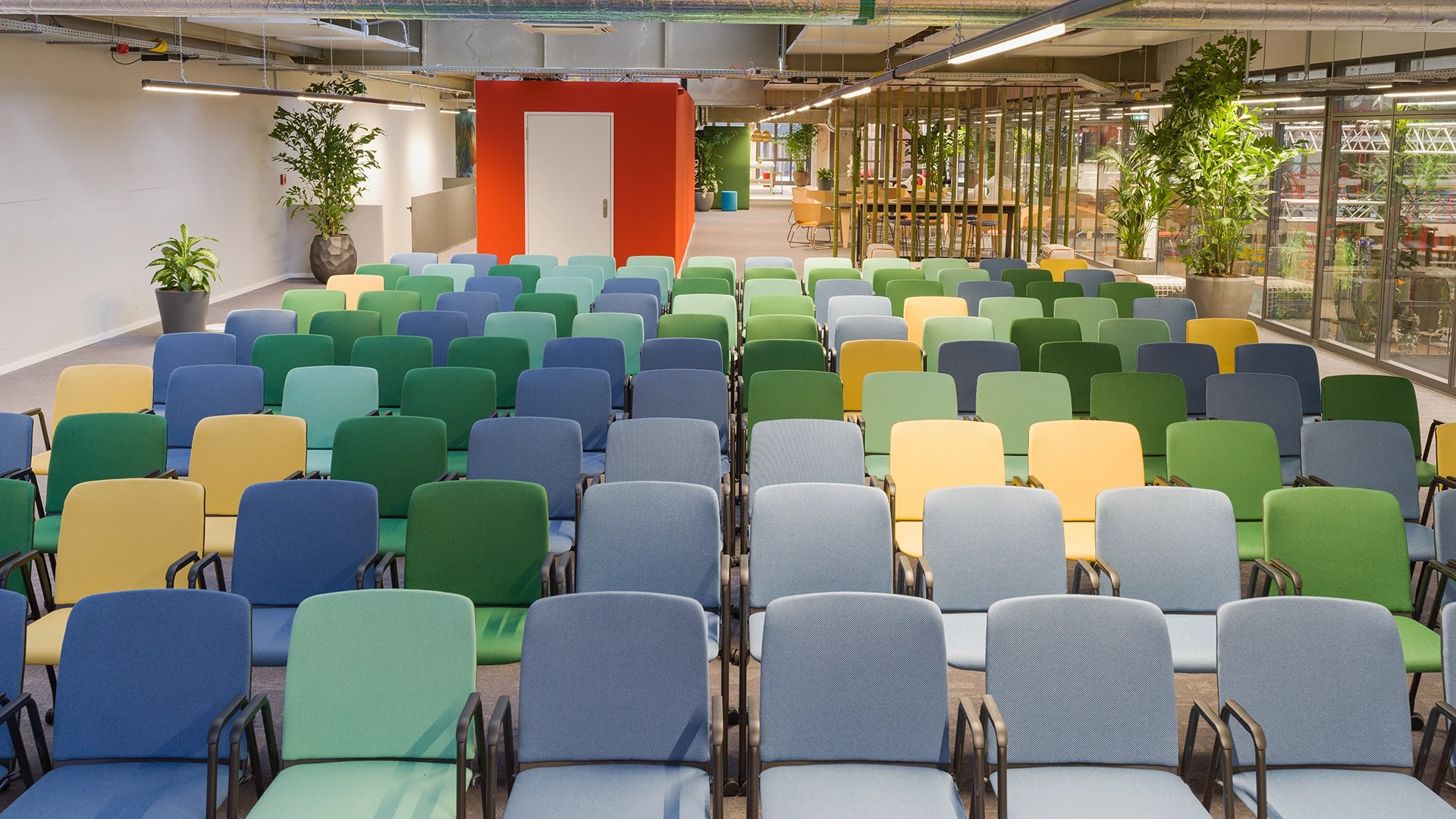 Blick auf einen Veranstaltungsbereich mit vielen bunten Stühlen in Reihen, ideal für Vorträge, Präsentationen oder Events.