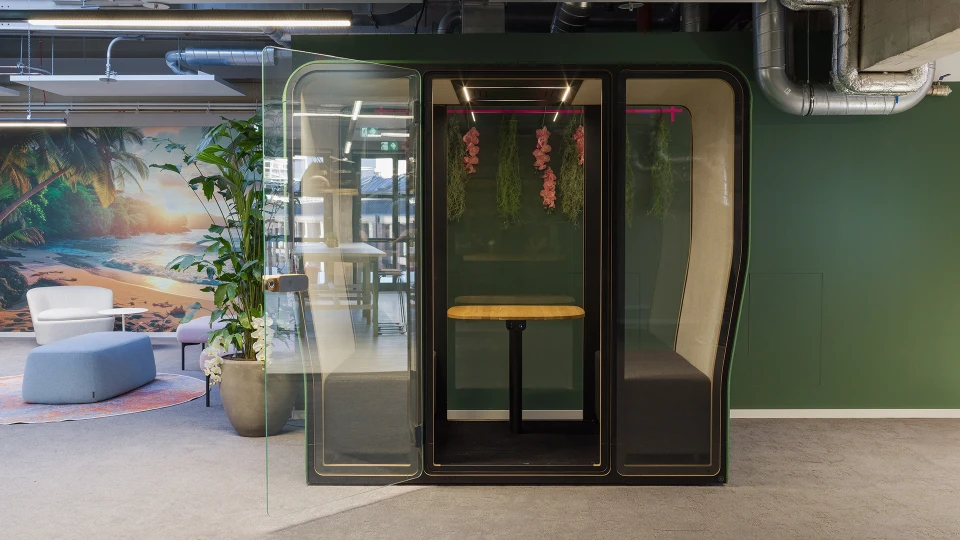 Großer heller Raum mit Glastrennwänden, Besprechungstischen und ergonomischen Stühlen, ideal für Workshops oder Meetings.