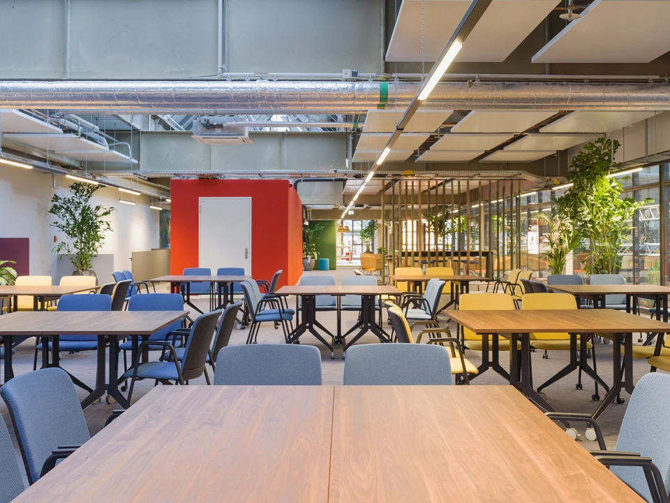 Bar- und Loungebereich mit Hochtisch, Kühlschränken, Lampenschirmen aus Bast und vielen Pflanzen.