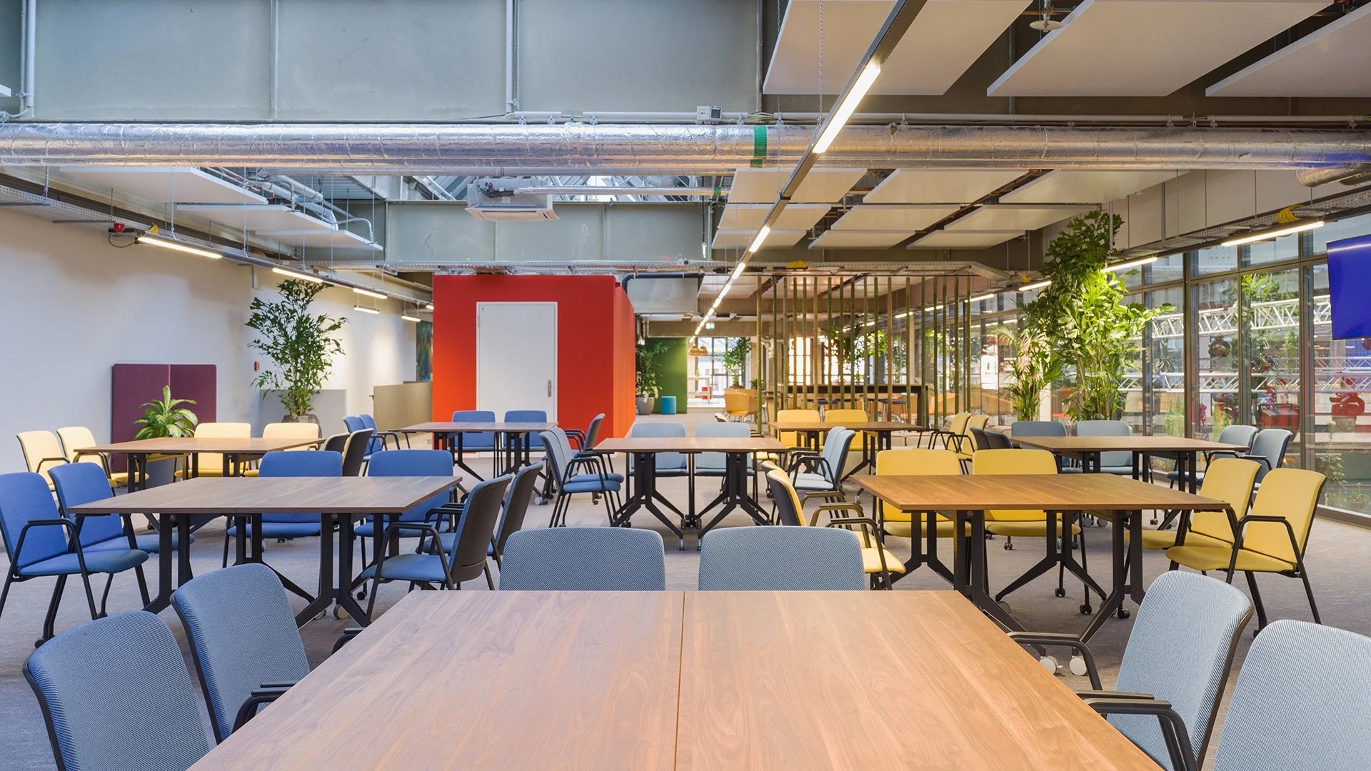 Bar- und Loungebereich mit Hochtisch, Kühlschränken, Lampenschirmen aus Bast und vielen Pflanzen.