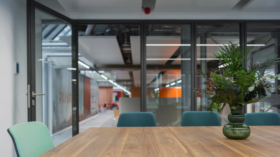 Rückzugsbereich mit bequemen Sitzmöbeln, Teppich und Wandgrafik eines tropischen Strandes.