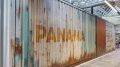 Großformatige Wandgrafik eines rostigen Frachtcontainers mit dem Schriftzug "PANAMA", Teil eines industriellen Designkonzepts.