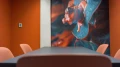 Side view of the meeting table in the 'Suriname' room, featuring a mural of a colorful frog on the wall.