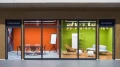 Zwei moderne Bürokonferenzräume mit Glasfronten, beschriftet mit 'SURINAME' in Rot und 'GUYANA' in Grün, ausgestattet mit Stühlen, Tischen und Dekorationselementen.